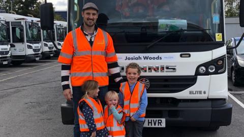 Josiah and siblings in front of bin lorry