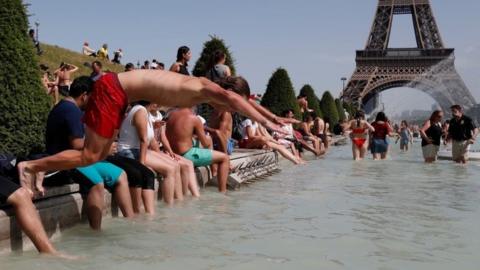 A boy jumps into the water of the Trocadero Fountain in Paris