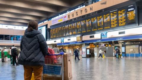 Passengers at Euston Station wait to find out if their trains are running on time as they prepare to leave the capital on December 19, 2020 in London