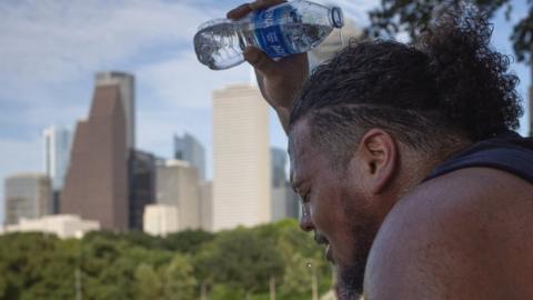 A man cools off with water in Houston, Texas. Photo: July 2023