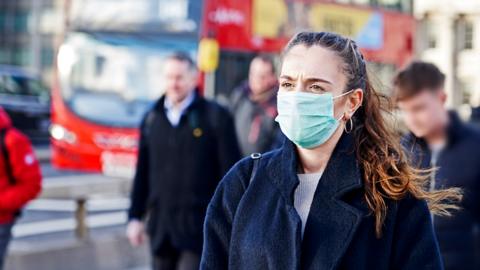 Woman walking in a mask