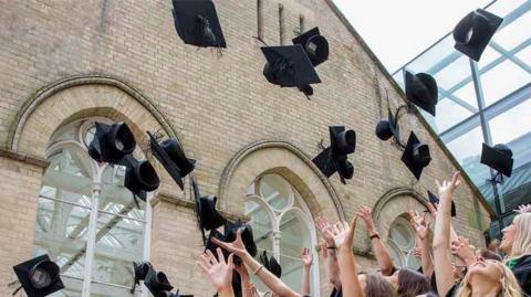 Students toss their caps in Nottingham Trent University's atrium