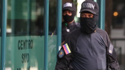 Members of the Sebin intelligence service stand outside the building housing the office of Venezuela's opposition leader Juan Guaidó, in Caracas, 21 January 2019