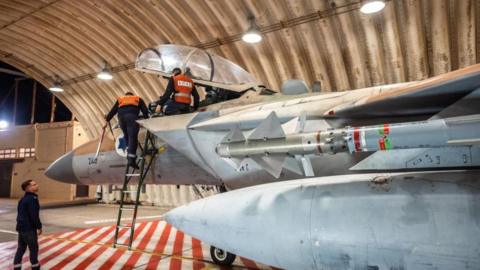 Crews work on an Israeli Air Force F-15 Eagle in a hangar