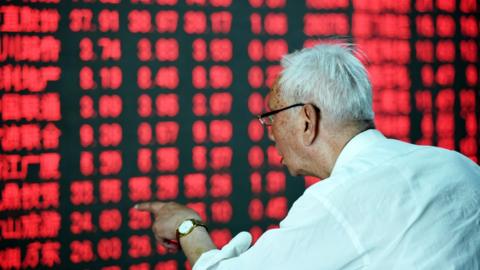 Chinese investor looks at a stock board