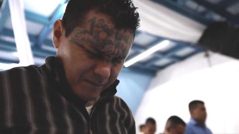 A man with face tattoos praying
