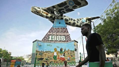 A man walking past a war memorial in Hargeisa, Somaliland