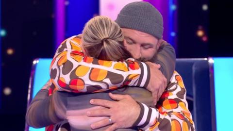 A contestant on The Wheel hugs rugby player Joe Marler.