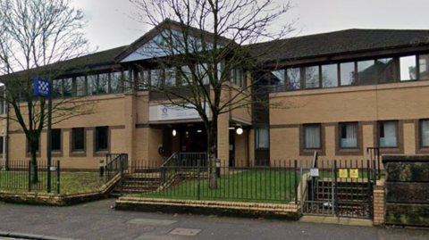 a google view of the exterior view of a sandstone police station building.