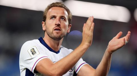 Harry Kane claps while playing for England