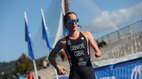 Claire Cashmore wearing sunglasses and running in Team GB uniform