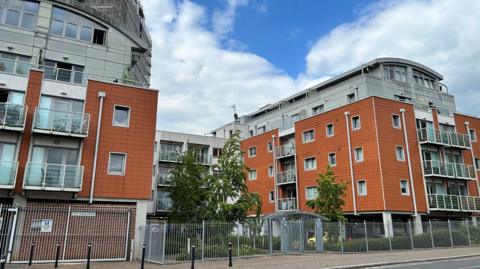 The outside of a block of flats with orange cladding