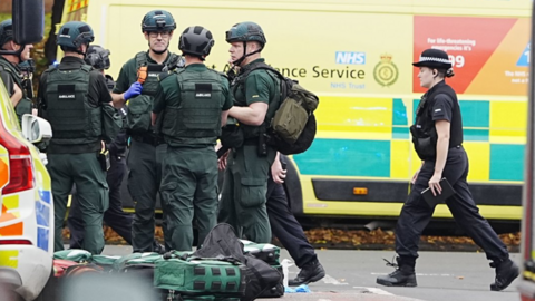 Emergency workers at the scene with an ambulance and firearms officers