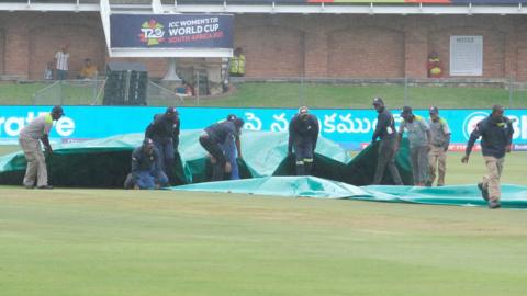 Ground staff protect the crease as rains stops the Group B T20 women's World Cup cricket match between India and Ireland at St George's Park in Gqeberha