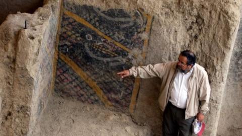 This handout file photo taken and released by Peruvian national news service Andina on November 10, 2007 shows Peruvian archaeologist Walter Alva pointing what is supposed to be the most ancient mural painting in America, in a temple in Chiclayo, more than 1000 kms north of Lima.