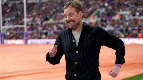Ricky Wilson of The Kaiser Chiefs entertains the crowd during a delay to the Rugby League World Cup group A match at St James' Park, Newcastle