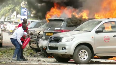 Two men using a fire extinguisher to put out a large fire