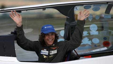 Mack Rutherford waiving sitting inside the cockpit of his Shark light aircraft