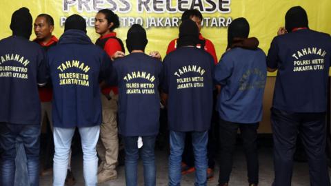 Indonesian police officers stand guard as men arrested in a raid are shown to the media during a press conference at a police station in Jakarta, Indonesia, 22 May 2017