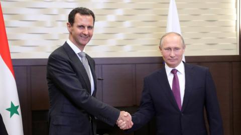 Russia's President Vladimir Putin (R) shakes hands with his Syrian counterpart Bashar al-Assad during a meeting in Sochi on November 20, 2017