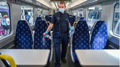 A railway worker cleans a carriage