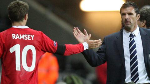 Gary Speed greets Aaron Ramsey as he leaves the field against Switzerland in October, 2011