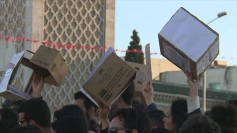 Protesters holding up cardboard boxes.