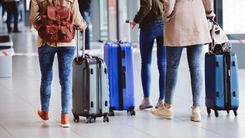 Stock image of people with suitcases