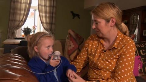 Harriet Corr uses her nebuliser while sitting next to her mum, Emma