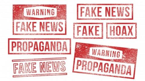 Rubber stamp imprints read "fake news" in red ink