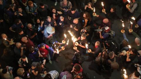 Protesters light candles at a protest in Tel Aviv, Israel on 6 April