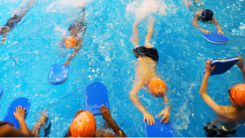 Swimmers in a pool with floats and swimming caps