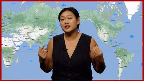 Frances Mao in front of world map