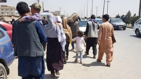 Afghans waiting outside Hamid Karzai International Airport on 21 August