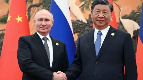This pool photograph distributed by Russian state owned agency Sputnik shows Russia's President Vladimir Putin and Chinese President Xi Jinping shaking hands during a meeting in Beijing on October 18, 2023