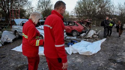 Emergency services work at the site of a missile strike in the village of Hroza, north-eastern Ukraine. Photo: 5 October 2023