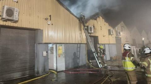 Firemen fighting a fire in the industrial units