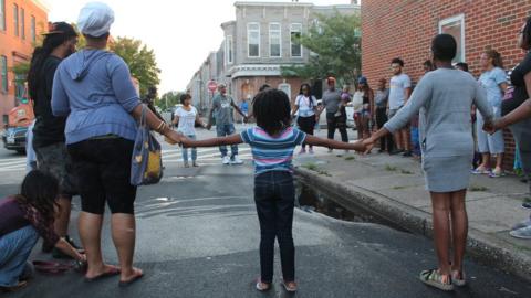 Prayer circle at site of Saturday's homicide