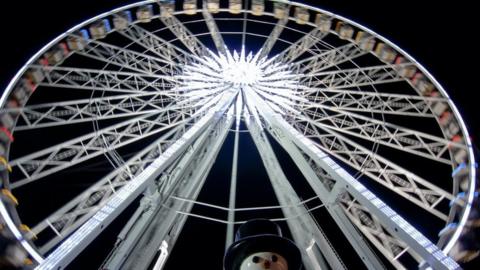 Ferris wheel at night with a snowman in front of it