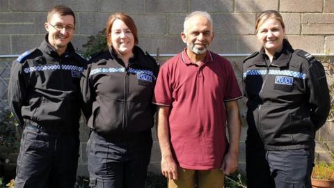 Abdullah Bhaiyat standing with three police constables in their uniforms