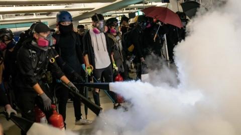 HK protesters letting off fire extinguishers