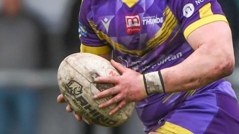 Newcastle Thunder shirt and player carrying a ball