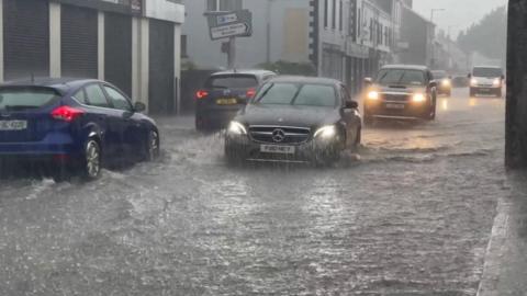 car driving through flood waters