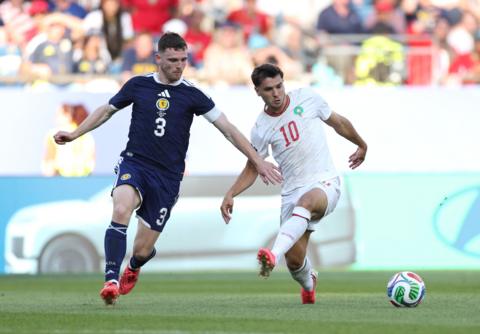 Andy Robertson of Scotland competes for the ball against Brahim Diaz of Morocco 