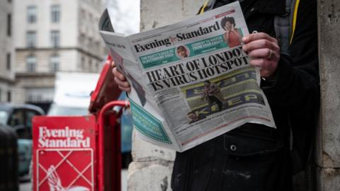 Man reading Evening Standard during the pandemic