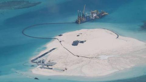 Chinese vessel, top centre, is used to expand structures and land on the Johnson Reef, called Mabini by the Philippines and Chigua by China, at the Spratly Islands