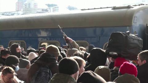 A soldier with a gun in crowds of civilians