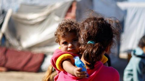 Displaced Palestinians, who fled their homes due to Israeli strikes, shelter in a tent cam