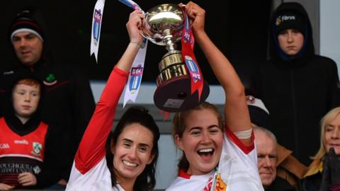 Loughgiel joint-captains Una McNaughton and Christine Laverty lift the Ulster Club Camogie trophy