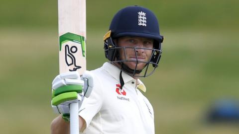 England batsman Jos Buttler raises his bat to celebrate making a century against New Zealand A